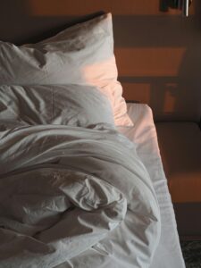 Unmade bed at night representing waking up at 2AM due to elevated cortisol and disrupted sleep